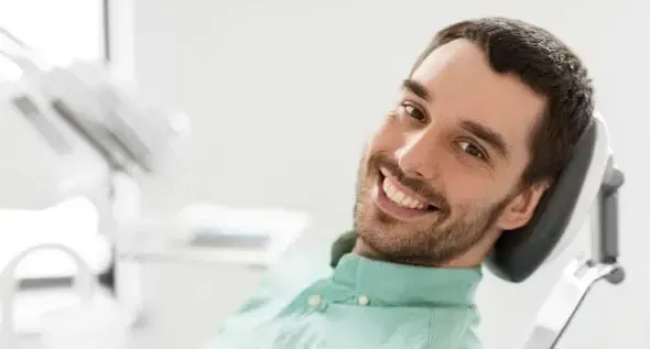 A woman is brushing her teeth with a blue toothbrush.