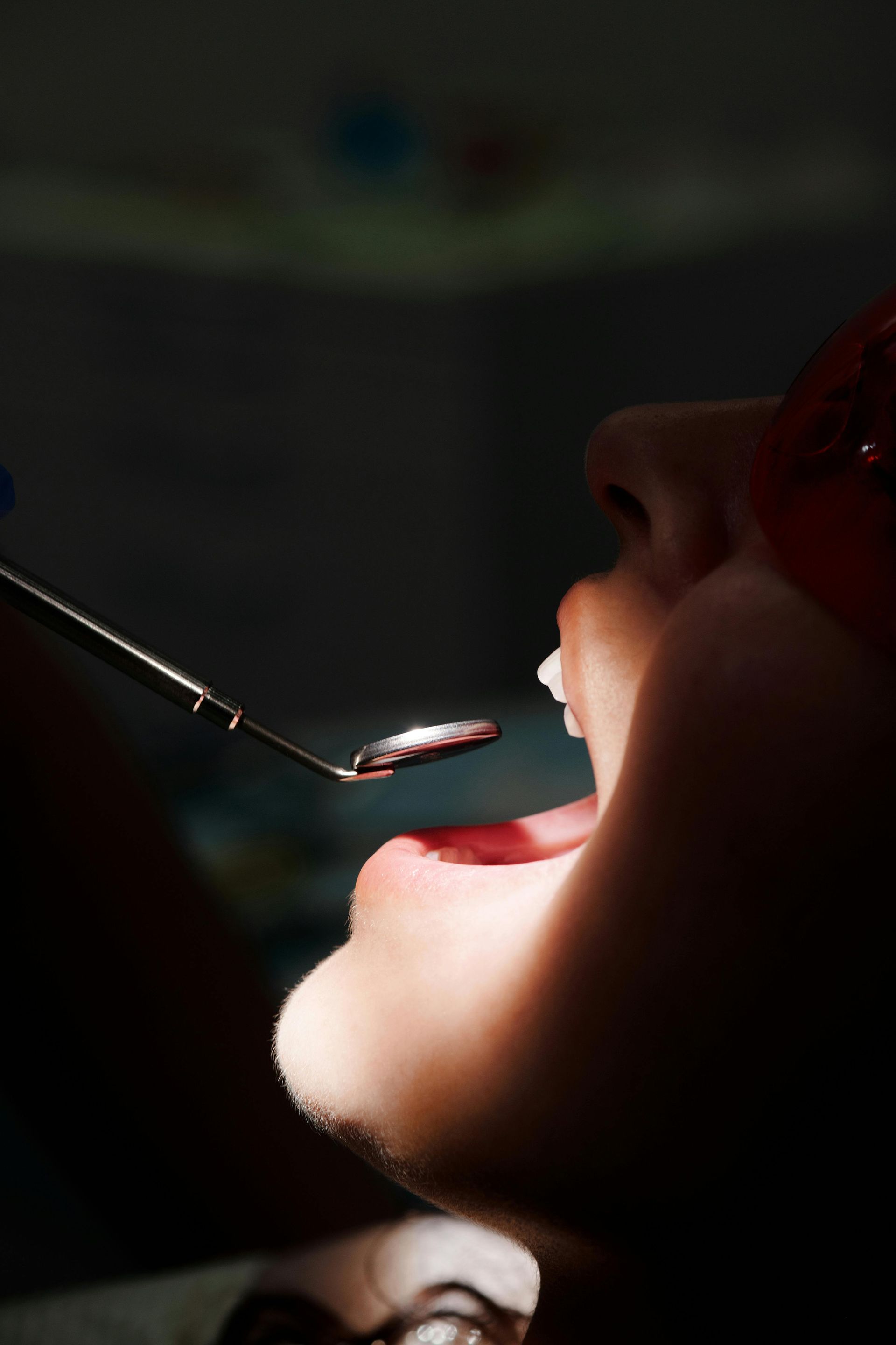 A woman is getting her teeth examined by a dentist.
