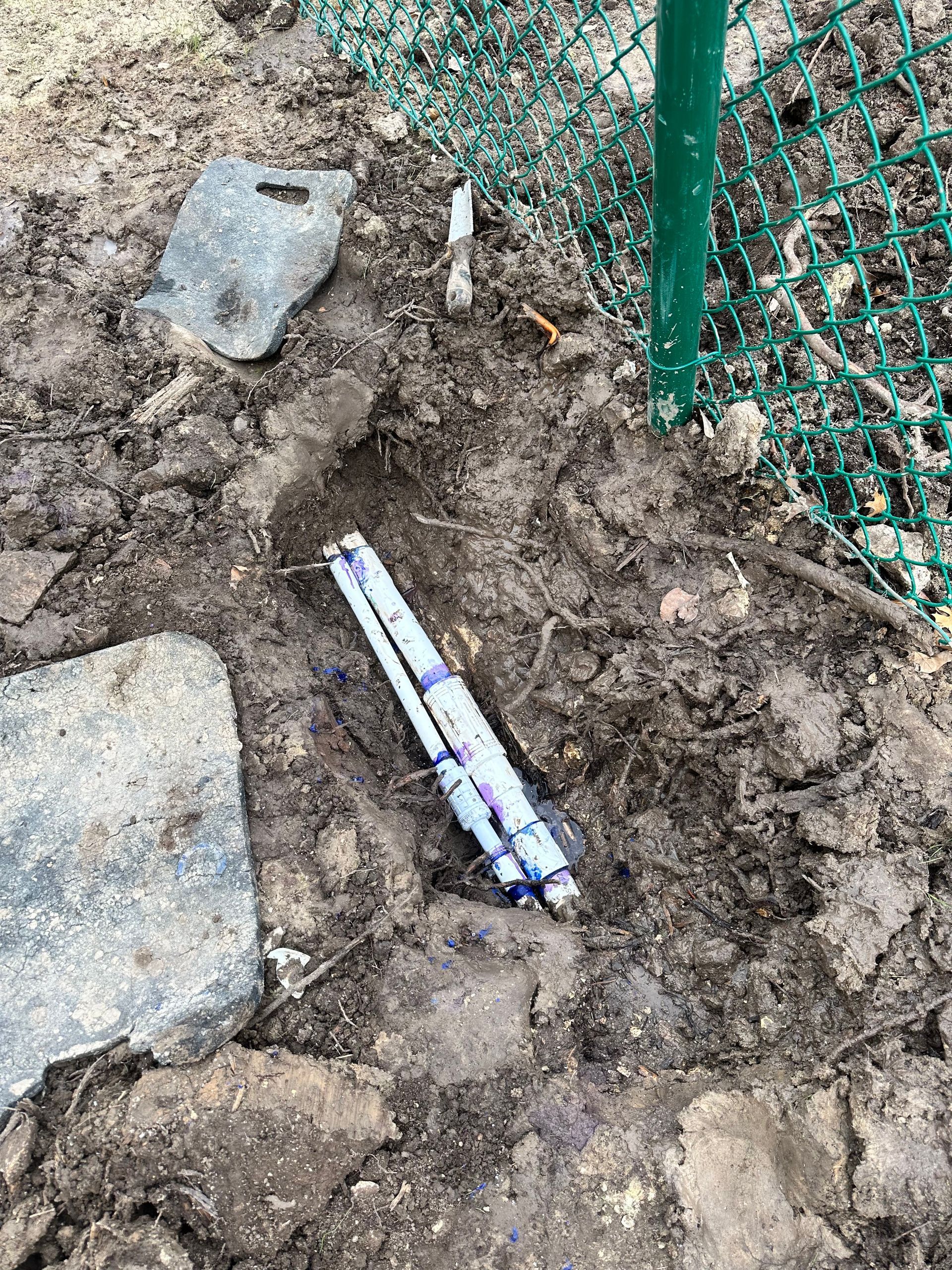 A piece of wrapping paper is laying on the ground next to a fence.
