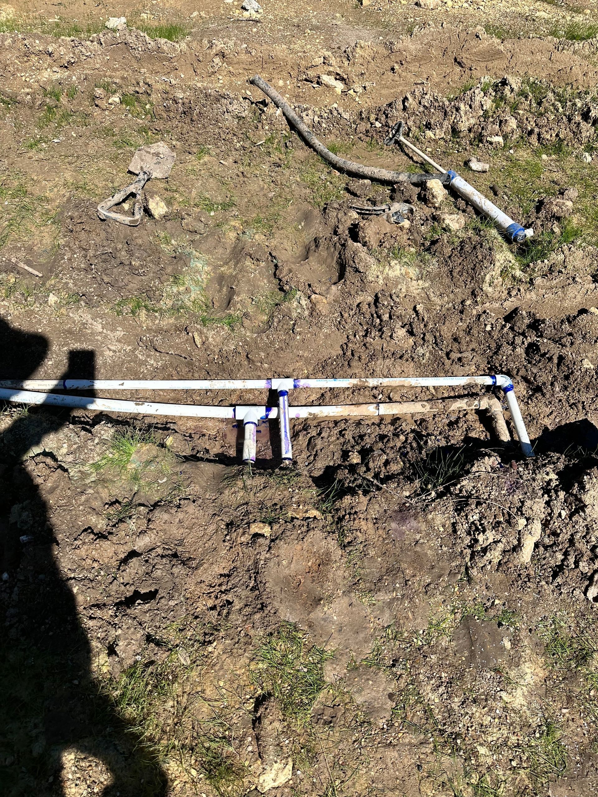 A person is digging in the dirt with a shovel.