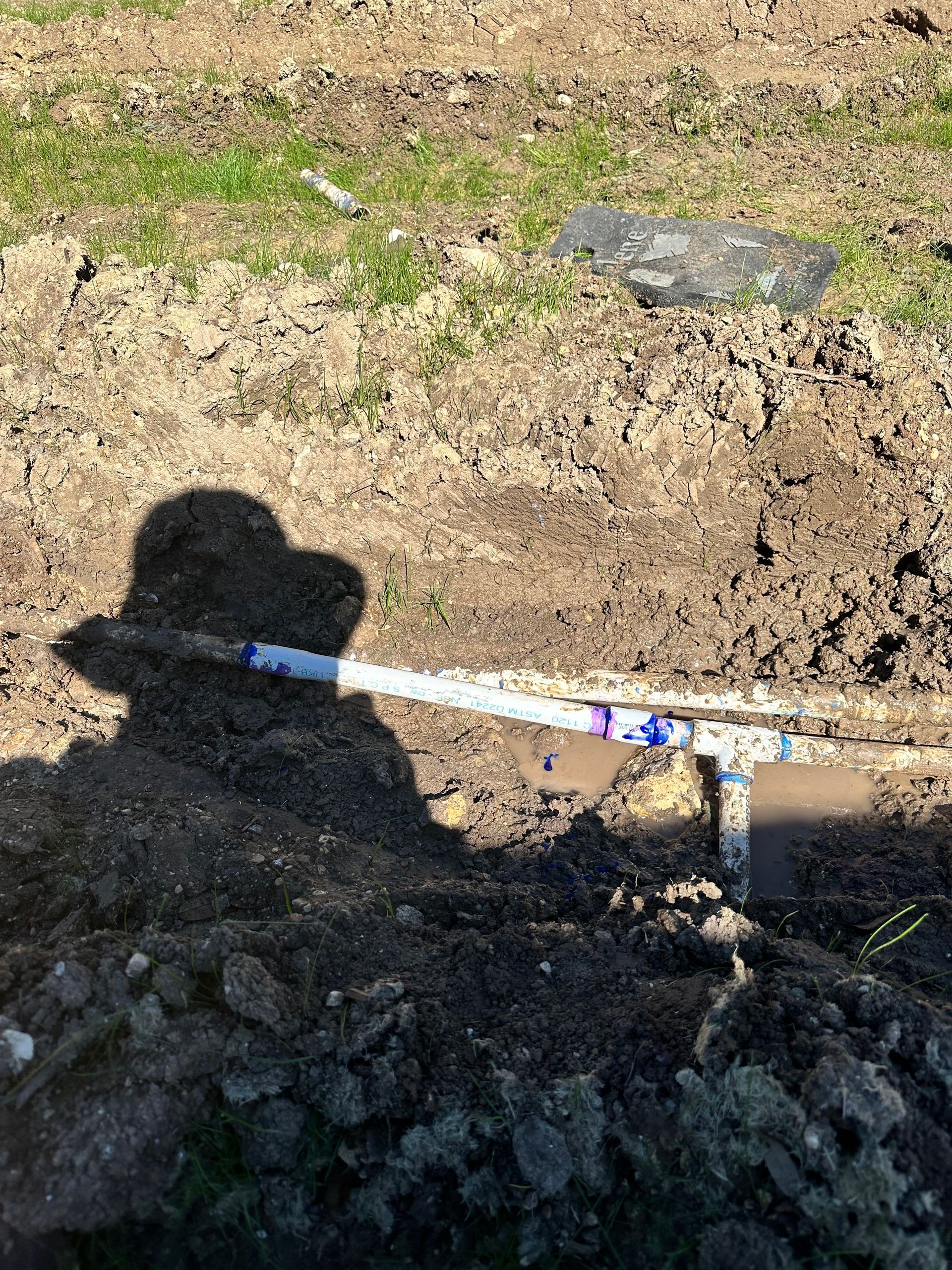 A person is digging in the dirt with a shovel.