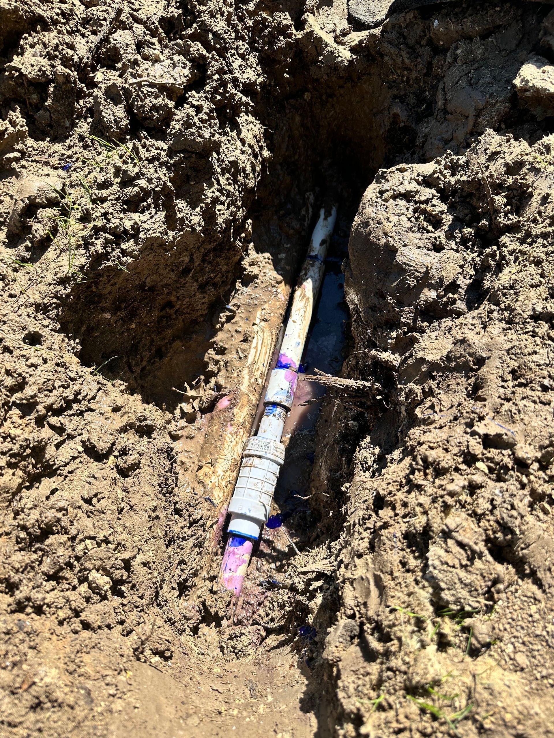 A pipe is sticking out of the ground in the dirt.