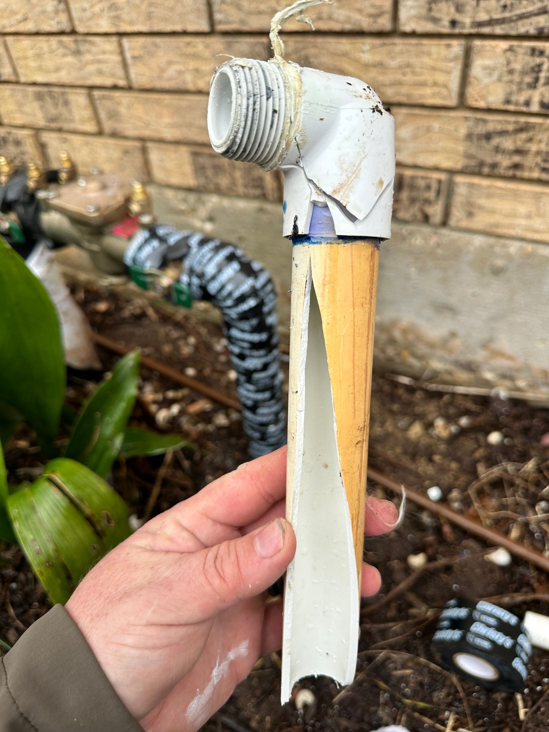 A person is holding a piece of pvc pipe in their hand.