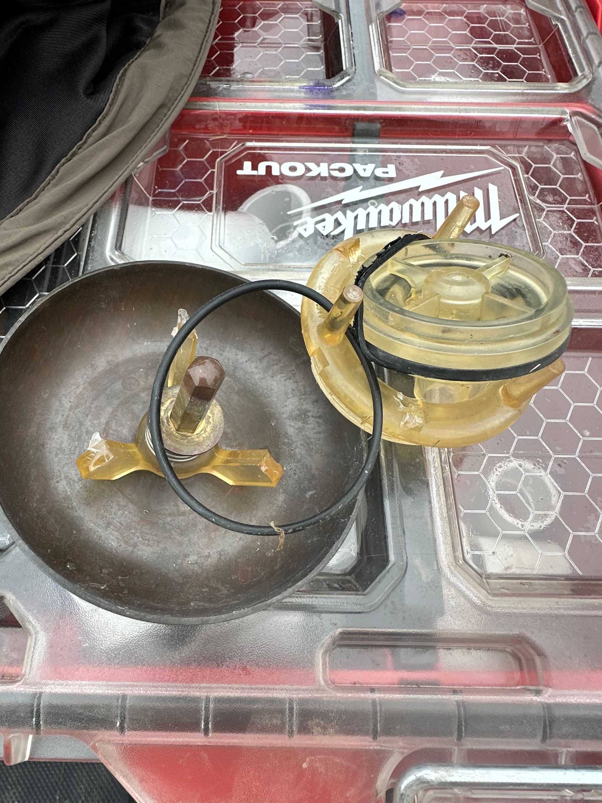 A piece of metal is sitting on top of a plastic container.