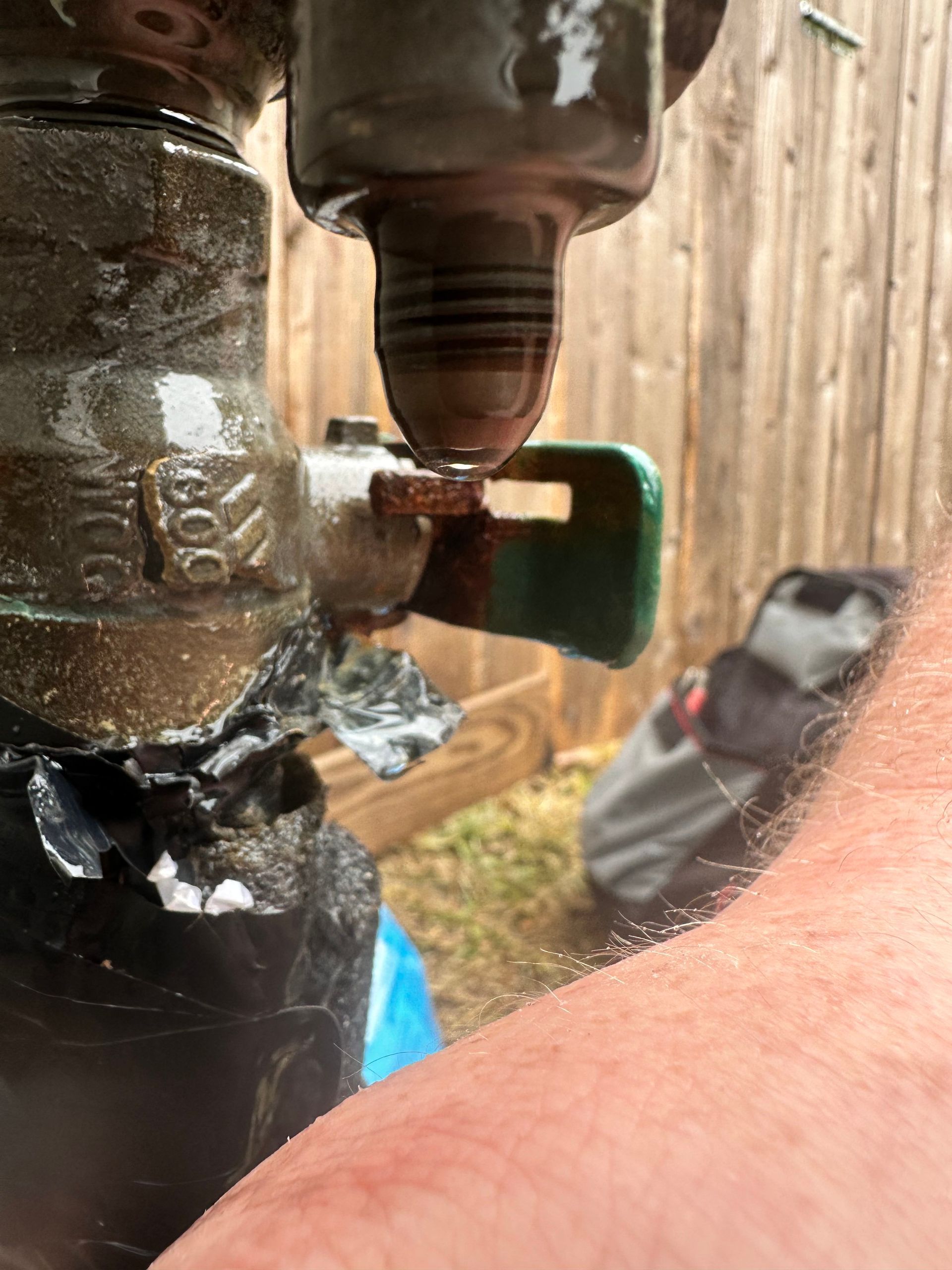 A person is holding a broken water valve on their arm.