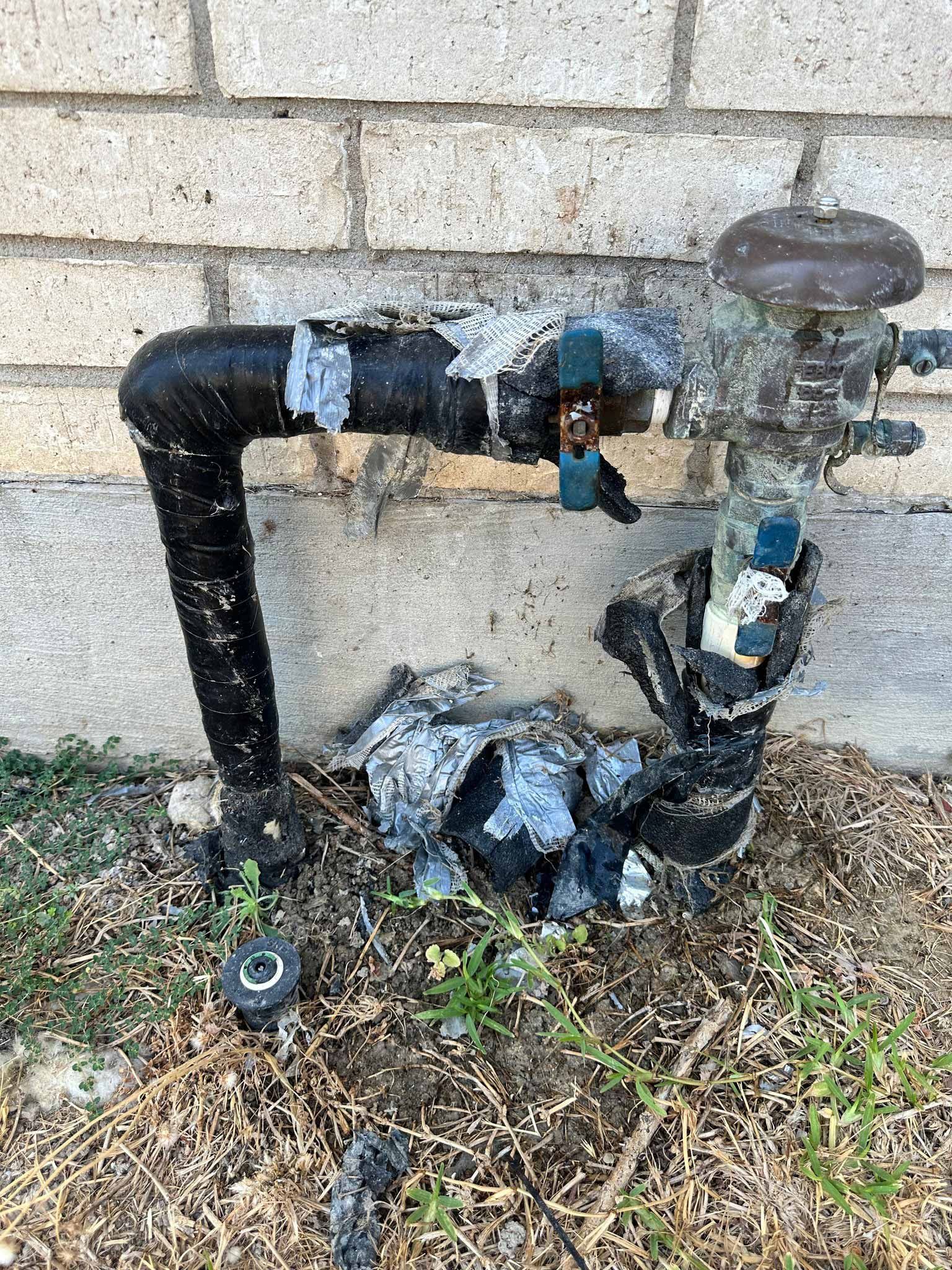 A water pipe in front of a brick wall.