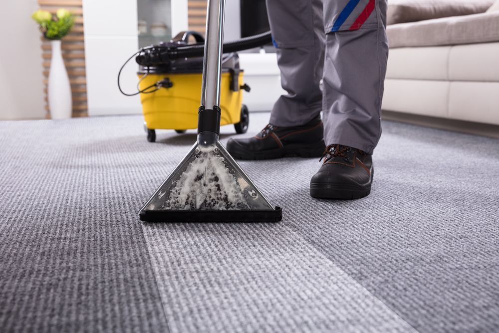 A Person Is Cleaning A Carpet With A Vacuum Cleaner — Wyong Commercial Cleaning In Tuggerah, NSW