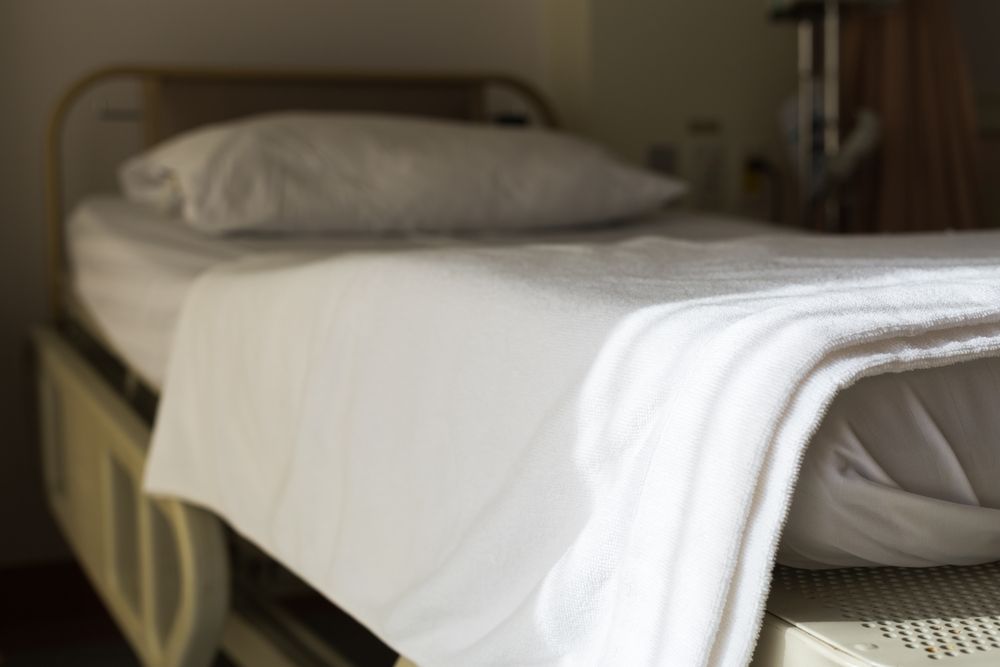 A Hospital Bed With White Sheets And A Pillow On It — Wyong Commercial Cleaning In Gosford, NSW