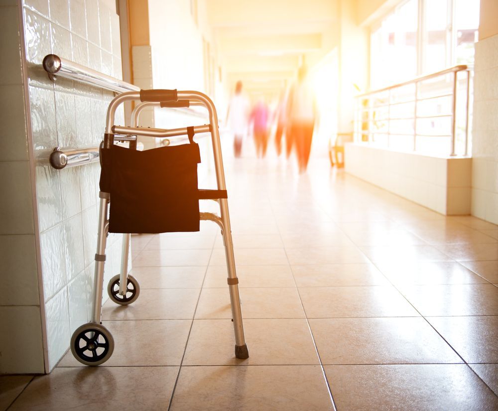 A Walker Is Sitting On The Floor In A Hospital Hallway — Wyong Commercial Cleaning In Morisset, NSW