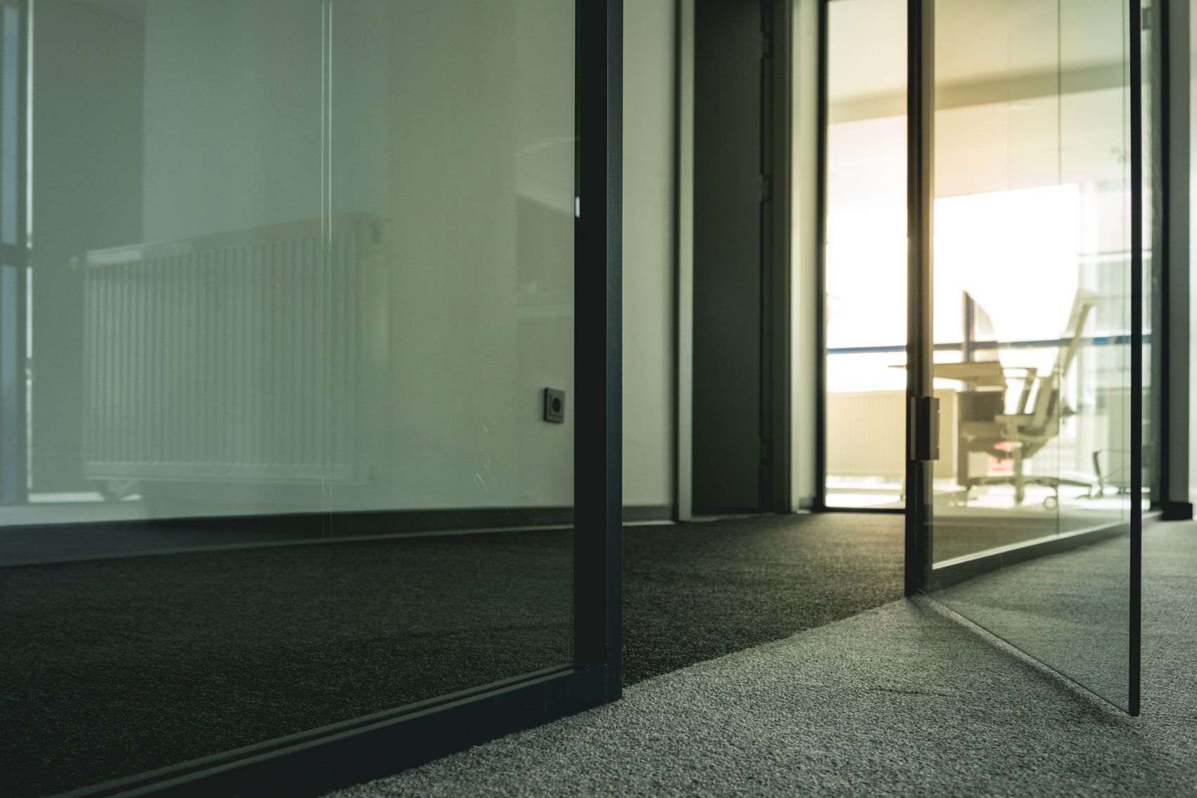 A Hallway In An Office Building With Sliding Glass Doors Leading To A Conference Room — Wyong Commercial Cleaning In Wyongah, NSW