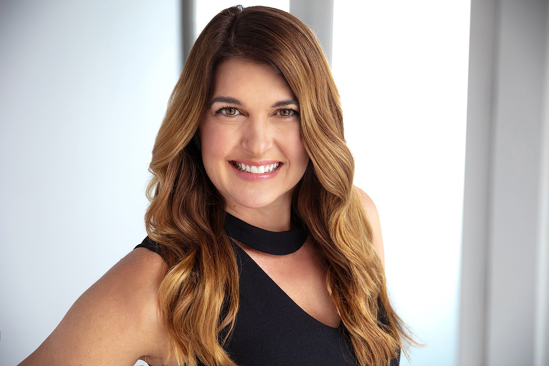 A woman in a black dress is smiling for the camera.