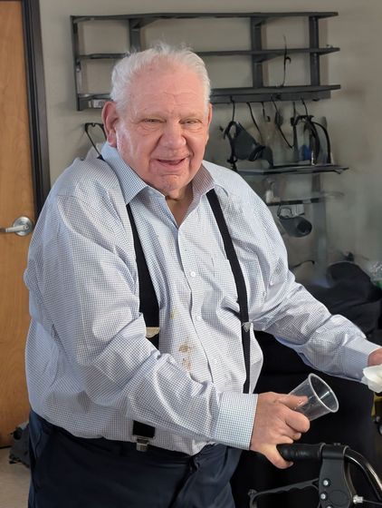 A woman in a green shirt is holding two books in her hands and smiling