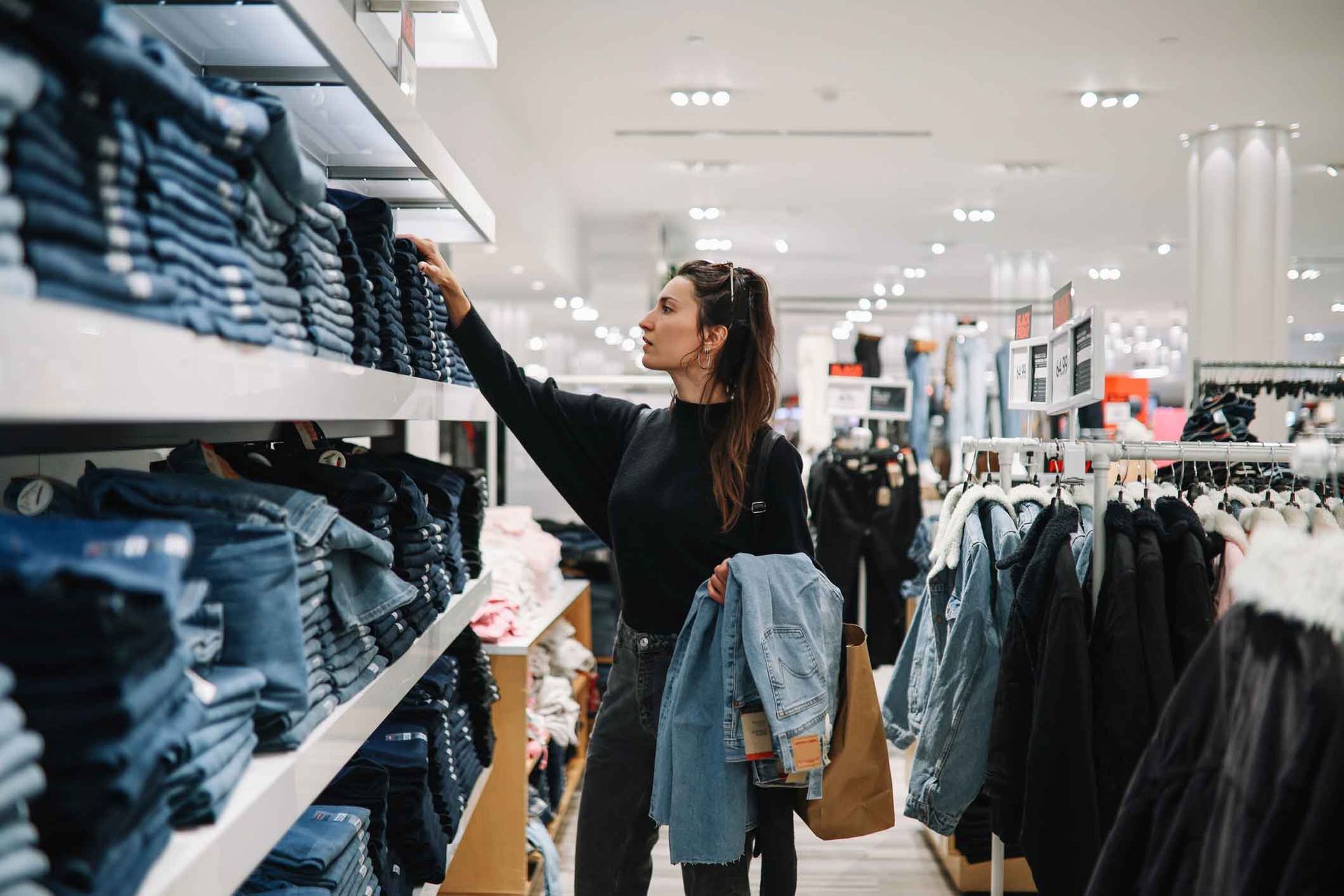 A woman is shopping for clothes in a clothing store.