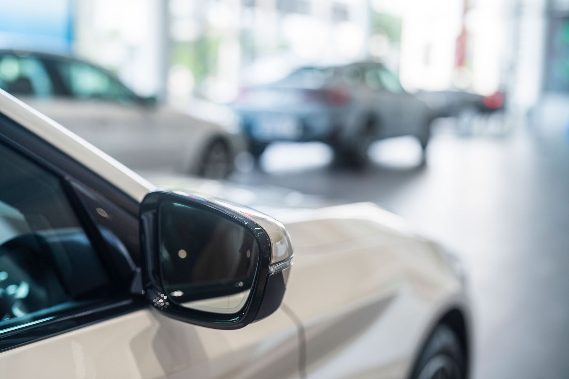 A close up of a car 's side mirror in a showroom.