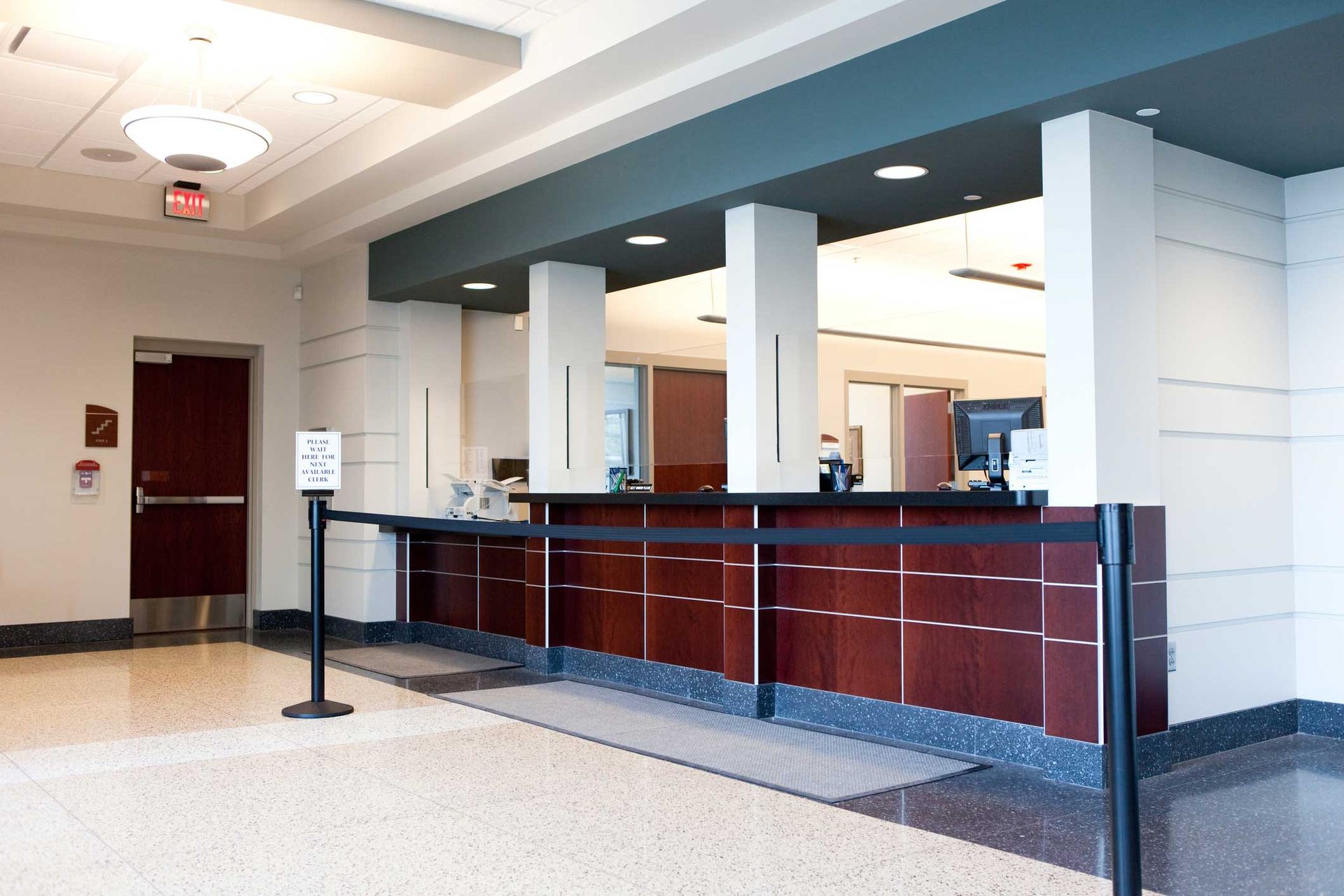 A lobby with a wooden counter and a black barrier