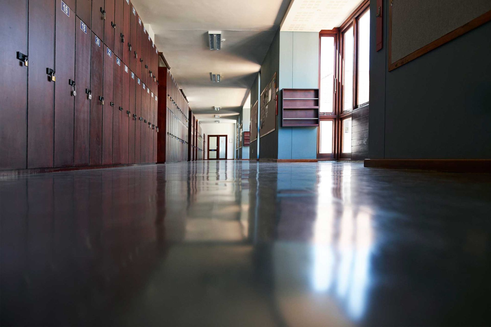 A long hallway with lots of lockers and windows