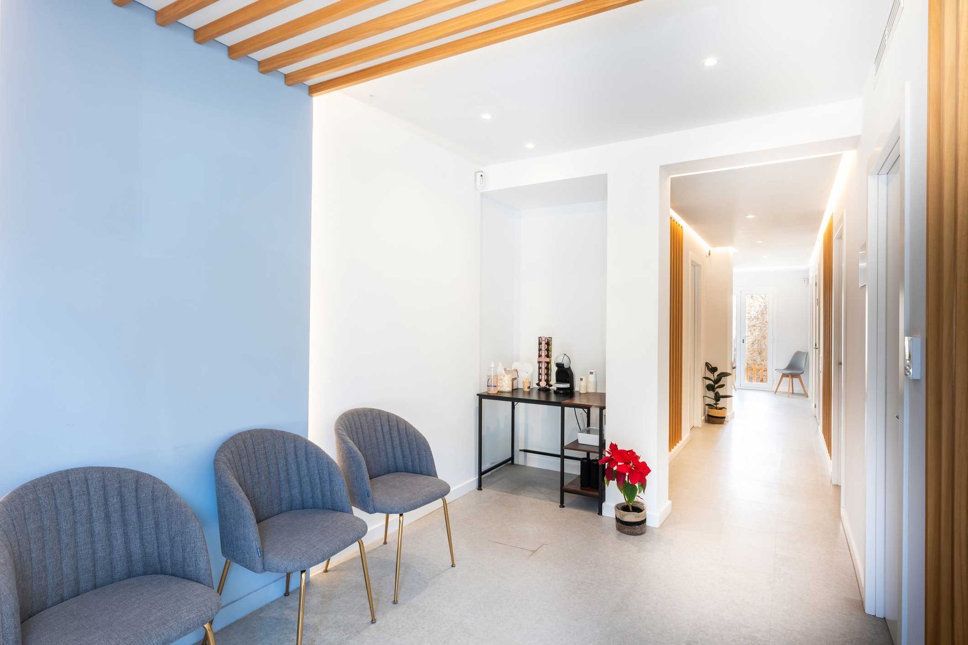 A waiting room with chairs and a table in a hallway.