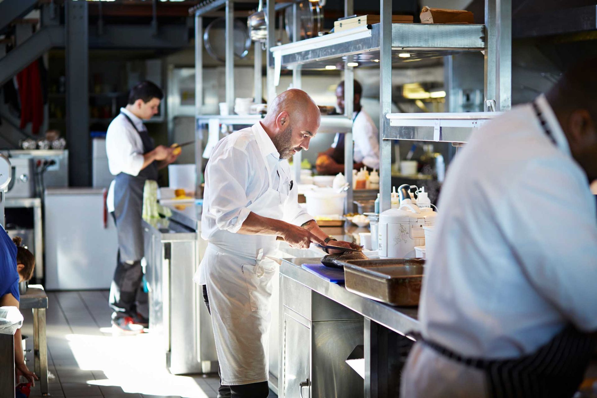 A man is standing in a kitchen preparing food.