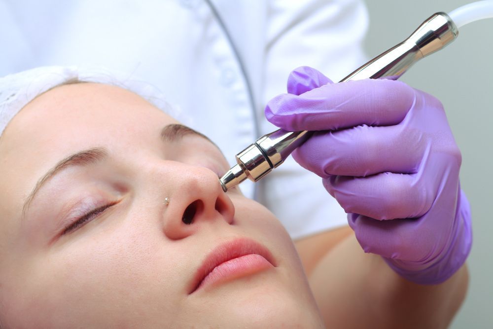 A Woman is Getting a Facial Treatment With a Machine — Coastal Skin & Laser in Noosa, QLD
