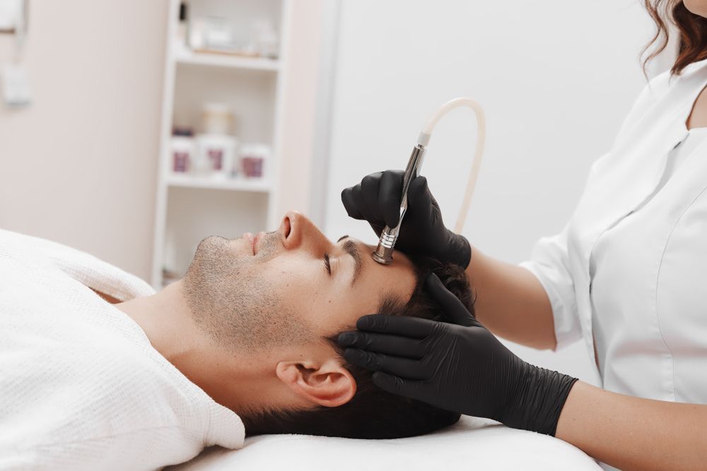 A Man is Getting a Facial Treatment — Coastal Skin & Laser in Coolum, QLD