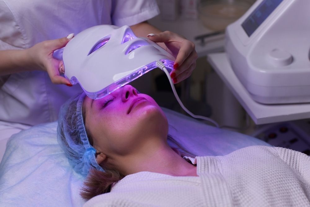 A Woman is Getting a Led Mask on Her Face — Coastal Skin & Laser in Caloundra, QLD