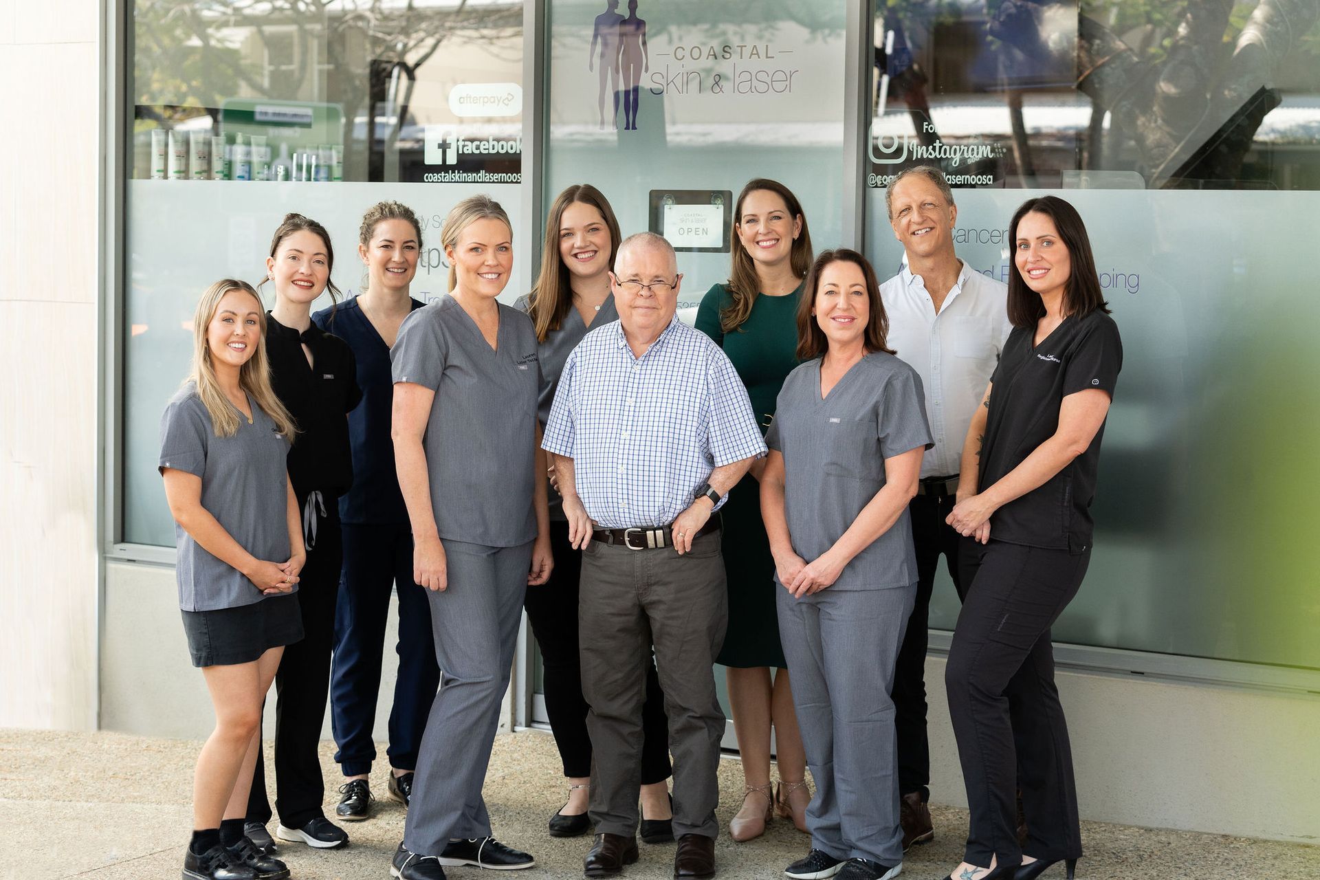 A Group of People Are Posing in Front of a Building — Coastal Skin & Laser in Tewantin, QLD