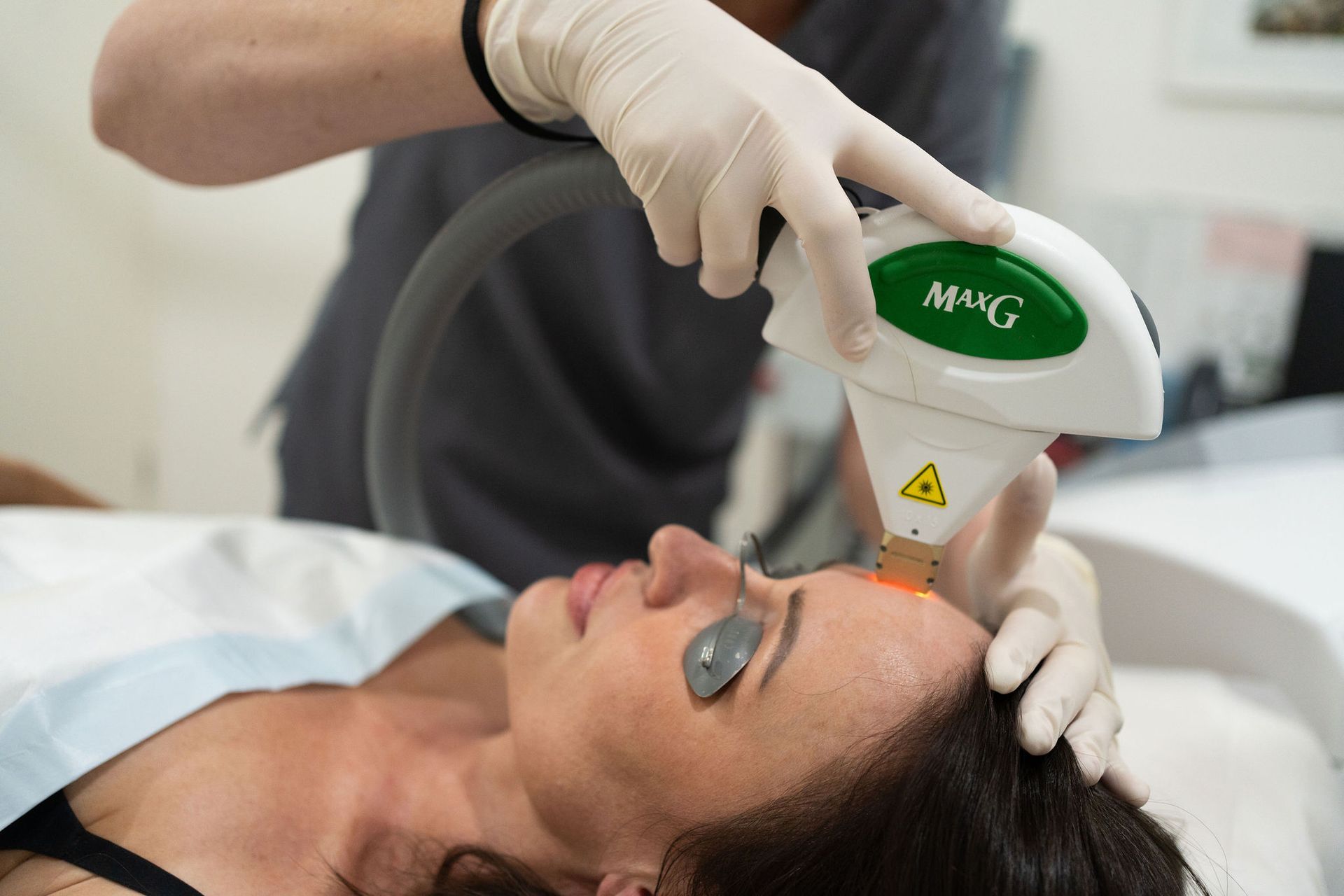 A Woman is Undergoing a Laser Treatment on Her Face — Coastal Skin & Laser in Tewantin, QLD