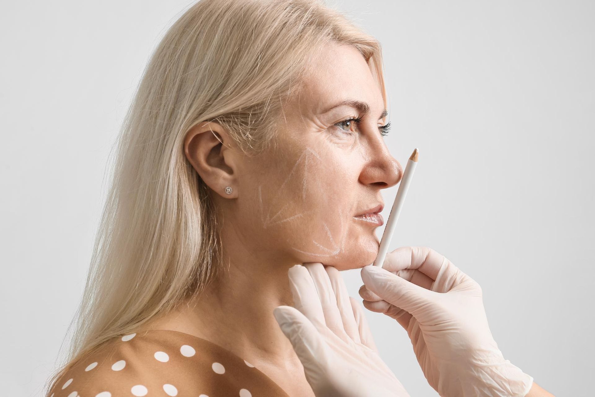 A Woman is Getting Her Face Measured by a Doctor — Coastal Skin & Laser in Noosa, QLD