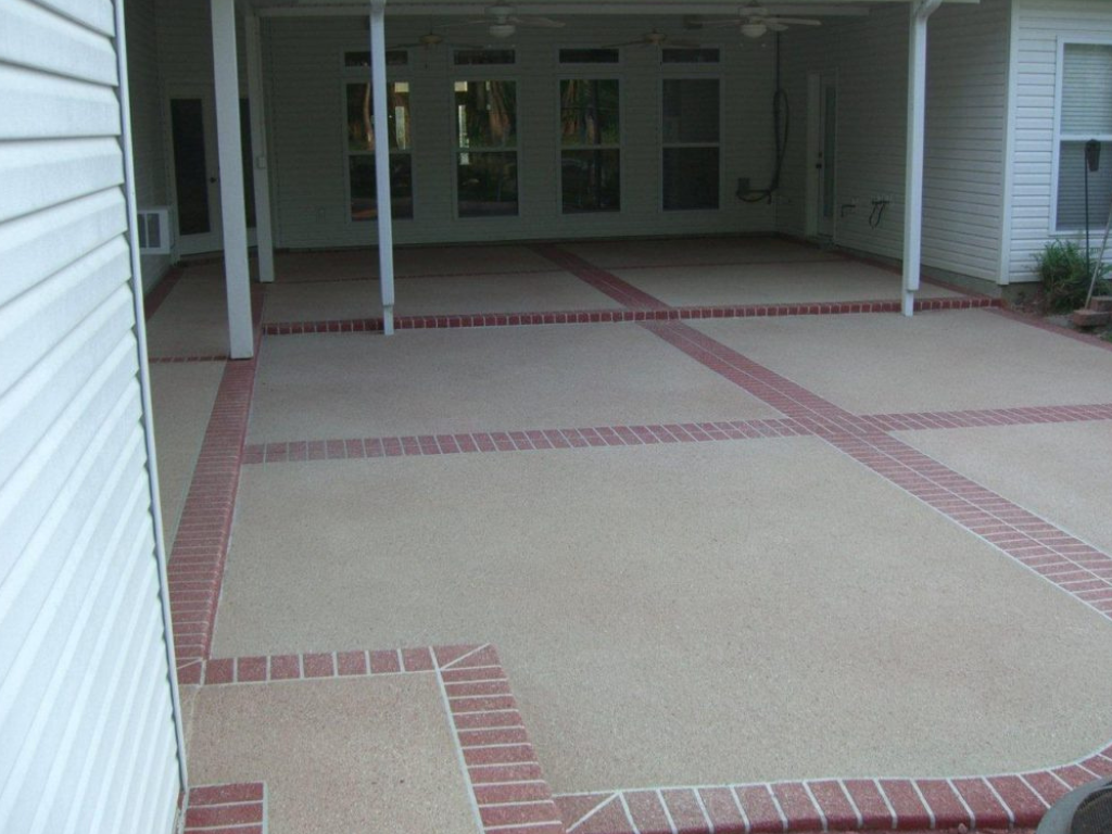 Covered patio with tan concrete and red brick borders.