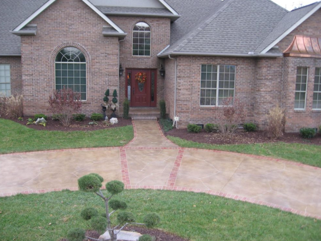 Brick house with walkway, arched window, red door, and landscaping.