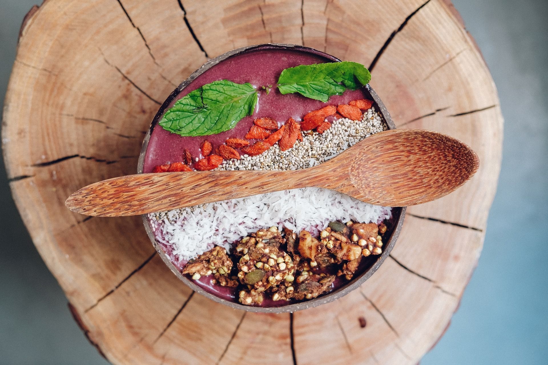 A bowl of food with a wooden spoon in it on a wooden table