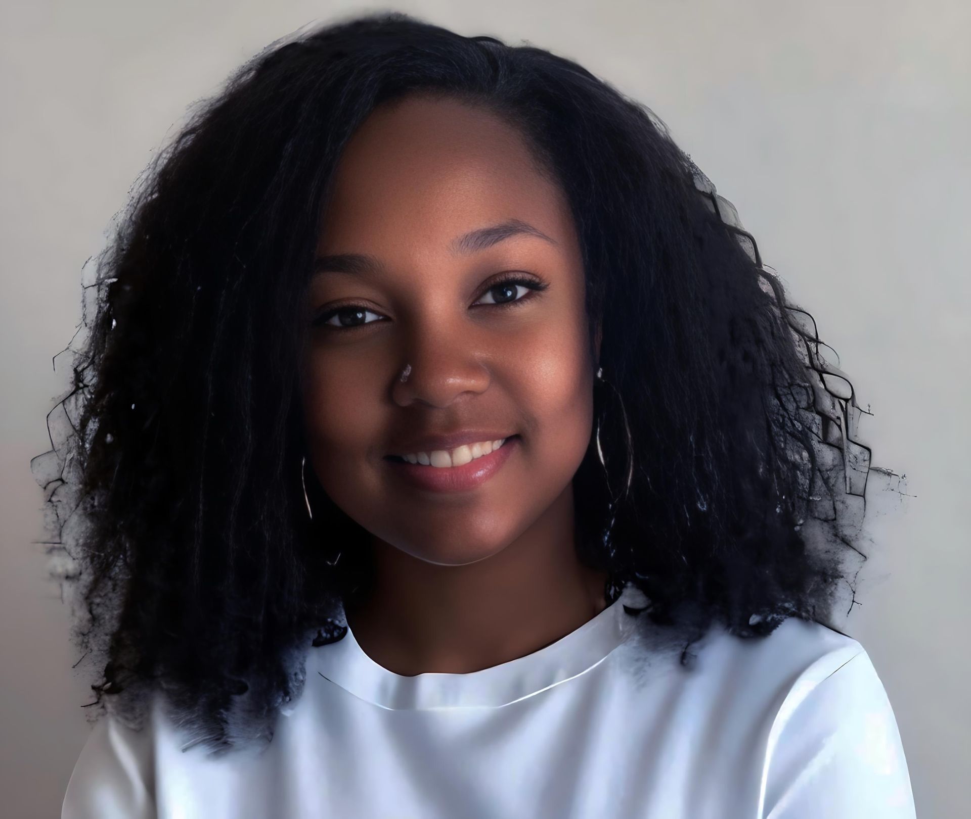 A woman wearing a white shirt is smiling.