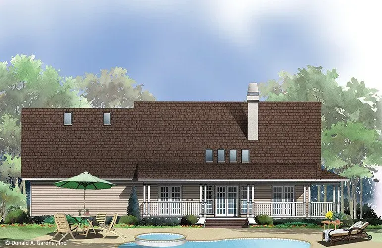 Rear view of a brown-roofed house with a porch overlooking a swimming pool and a green lawn.