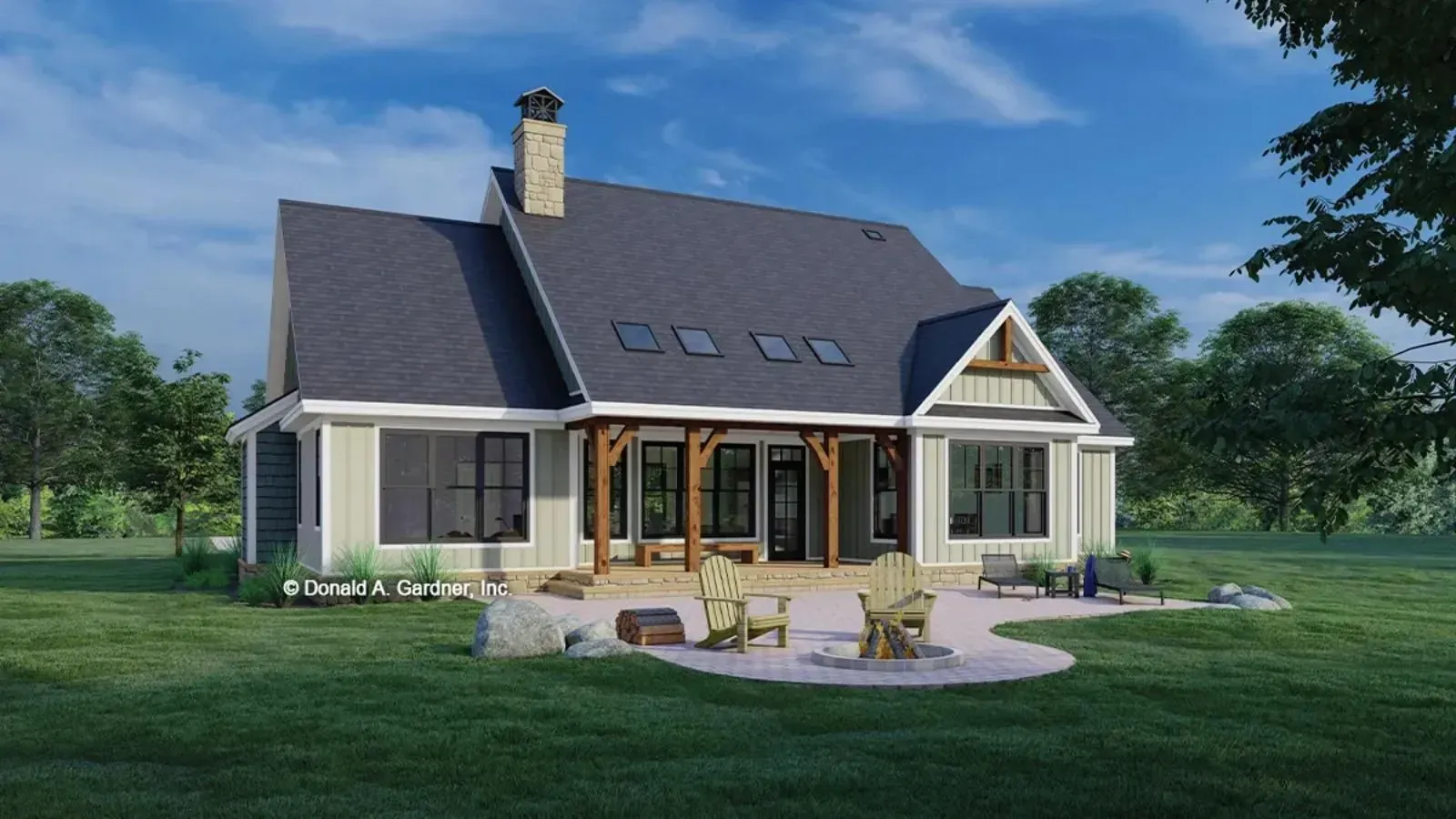 Rear view of a modern farmhouse with a patio, fireplace, and green lawn.