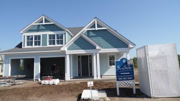 New construction house with blue accents, open garage, and a 
