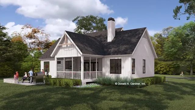 White farmhouse with porch, chimney, and black roof. People on a patio in front. Green grass and trees.