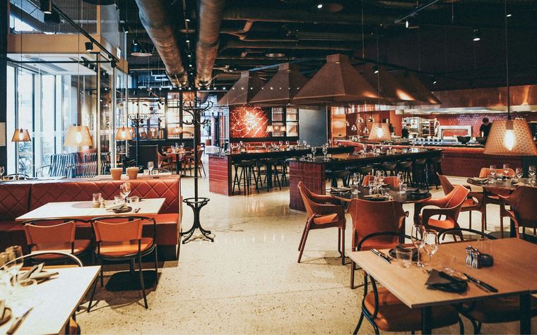 A large dining room with tables and chairs in a restaurant.