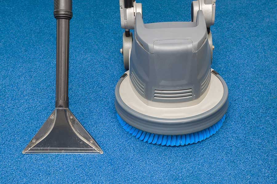 A Vacuum Cleaner is being Used to Clean a Blue Carpet — Coffs Carpet Cleaning in Coffs Harbour, NSW