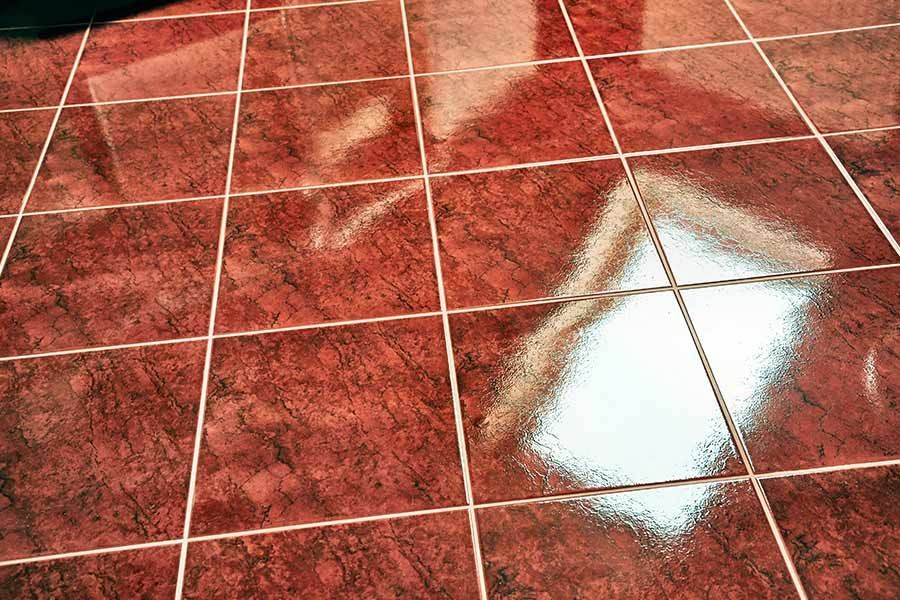 A Close up of a Red tiled Floor with a Reflection of a Window — Coffs Carpet Cleaning in Coffs Harbour, NSW