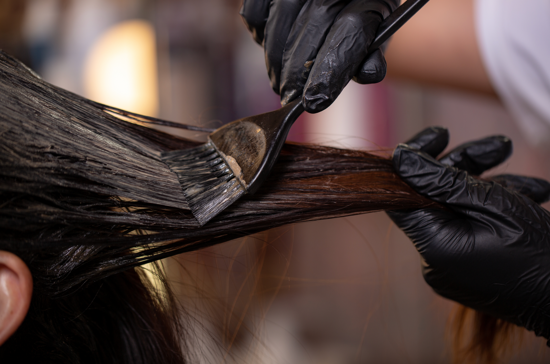 A woman is getting her hair dyed by a hairdresser.