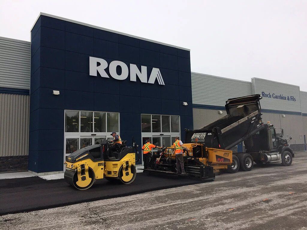 Une rangée de camions est garée devant un magasin Rona.