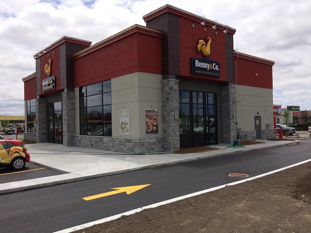 Une petite voiture jaune est garée devant un fast-food.