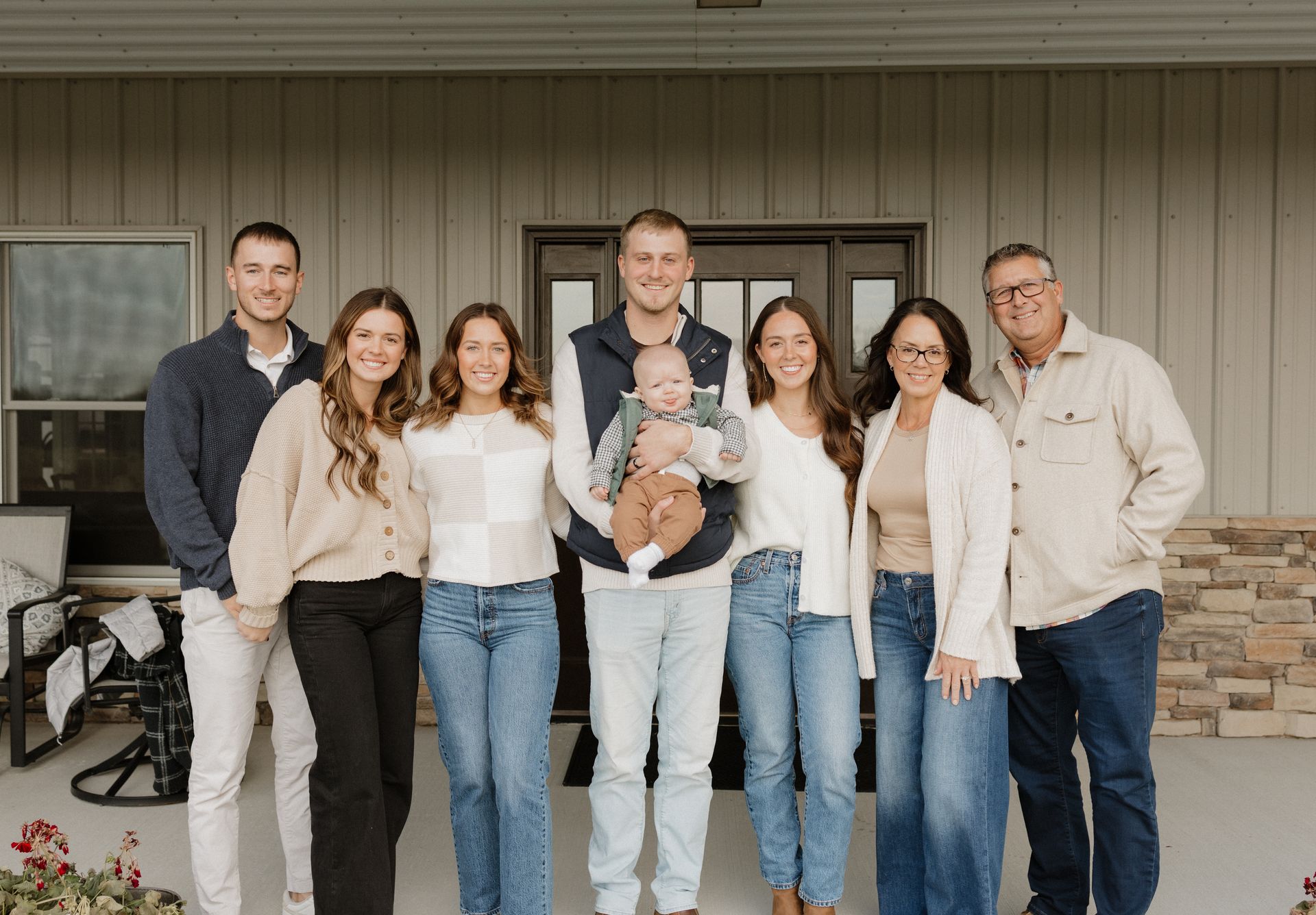 A family is posing for a picture together in front of a tree.