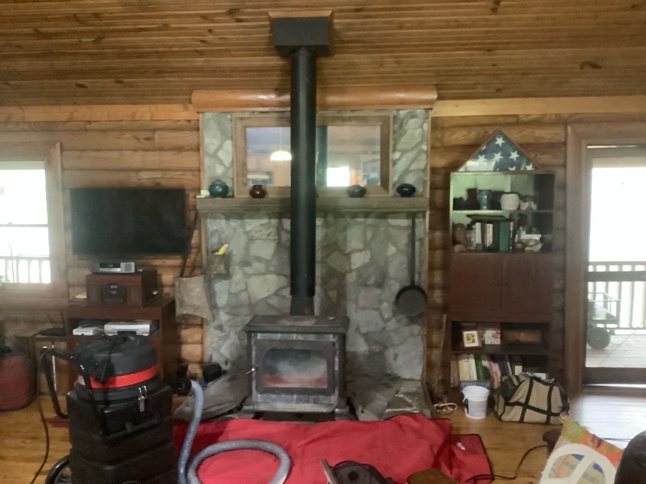 A living room with a wood stove and a vacuum cleaner