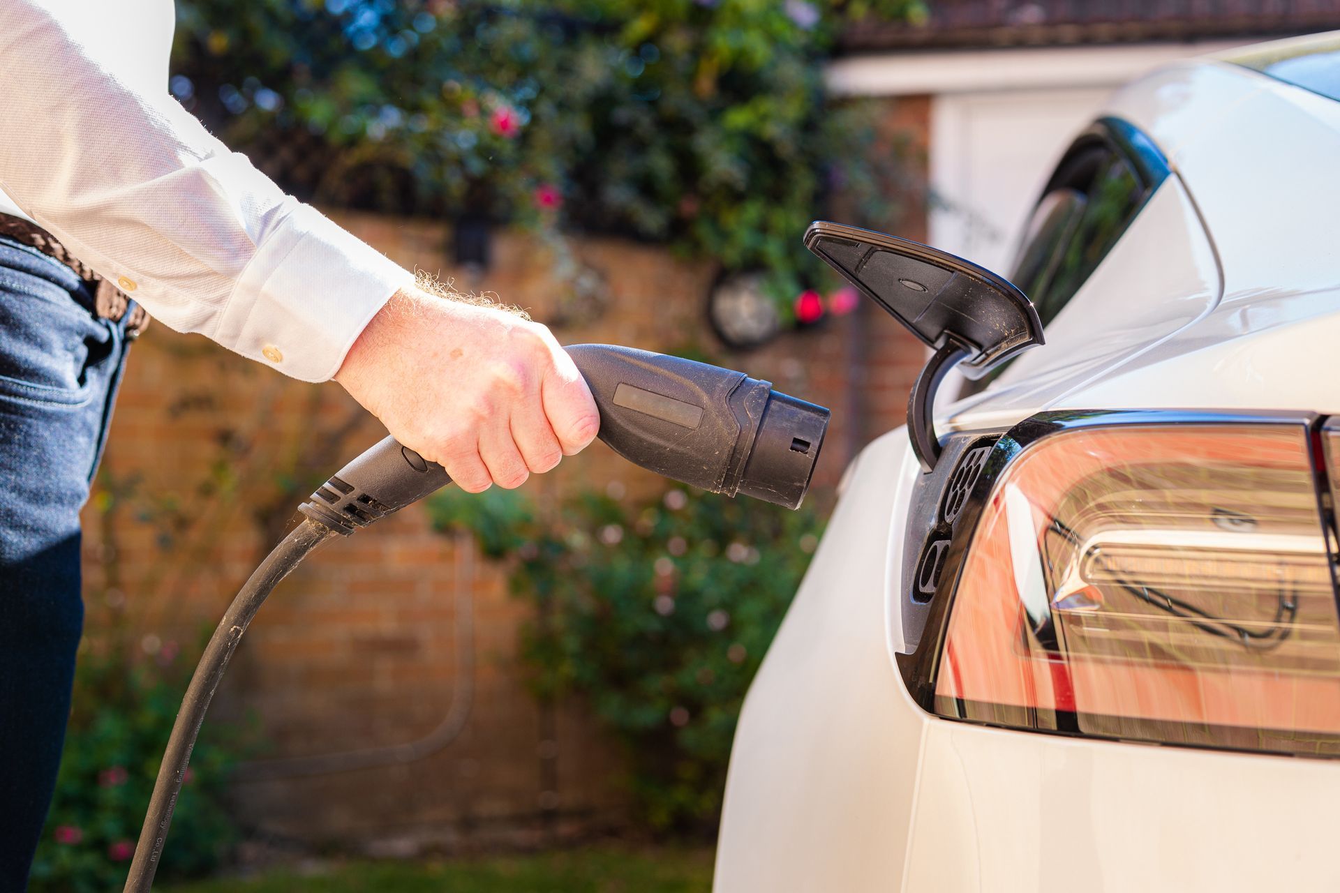 A home owner is charging an electric car with a charger installed by Patriot Electrical Solutions.