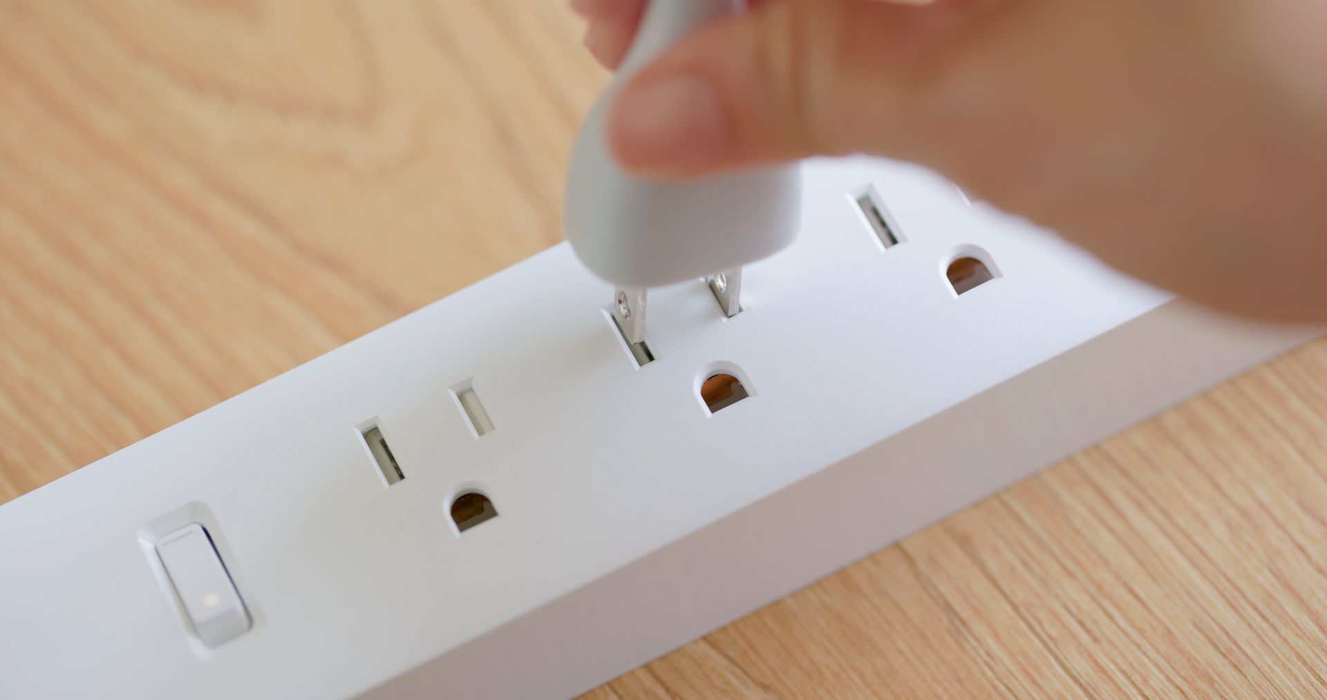 Closeup of parent teaching child about safe use of electrical outlets at home in Appleton, Wisconsin