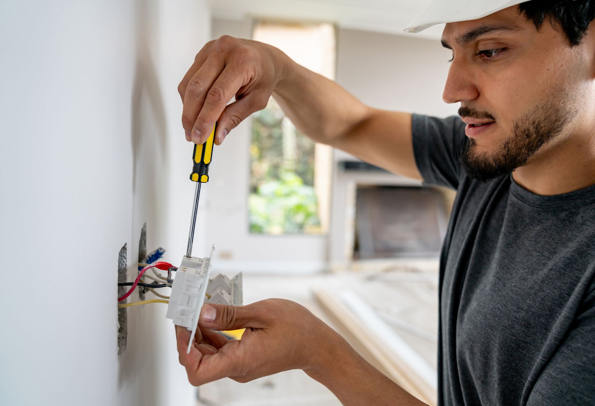 Electrician installing a new power socket with precision and care.