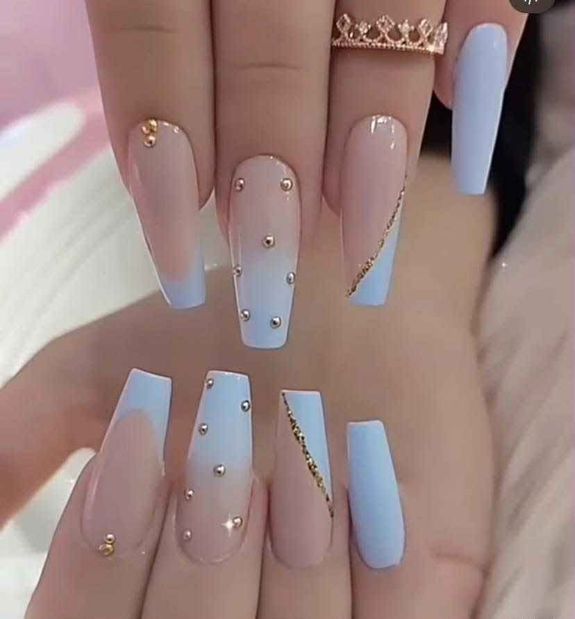 A woman 's hand with long nails and a crown on her finger.