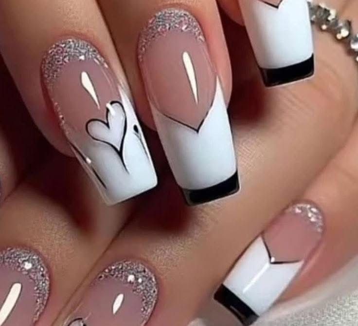 A close up of a woman 's nails with a heart design on them.