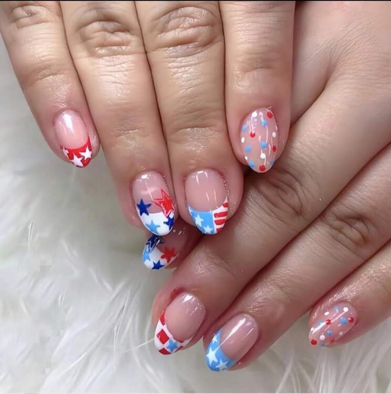A woman 's nails are decorated with red white and blue stars
